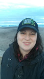 Picture of Laura Joki Woman with long brown hair in a grey snow jacket and black baseball cap