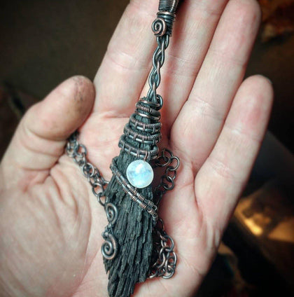Hand holding witches broom made from crystals