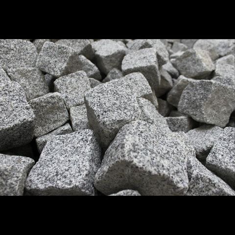 Speckled white with black chunks of granite stone in a pile