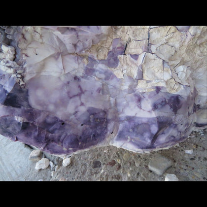 Purple and white Tiffany Stone above a smooth gray rock with smooth stones in it and white chalky rock with cracks in it above