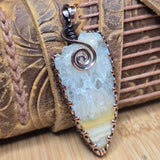 Necklace with a large, textured stone pendant on a woven surface