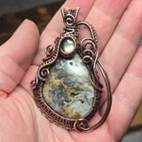 Decorative pendant with a stone held in a hand