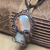 Necklace with a pendant featuring a large stone on an embossed surface