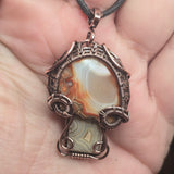 Jewelry pendant with intricate design held in a hand