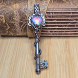 Decorative key with a colorful gemstone on a wooden background