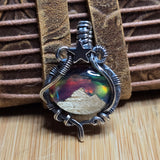 Metallic pendant with star and circular design on a textured surface