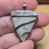 Blue and purple bracketed Jasper sterling silver pendant held in hand