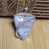 Pink Blue Purple stone pendant with silver wire wrapping on a wooden surface