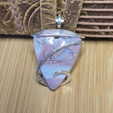 Pink Blue Purple stone pendant with silver wire wrapping on a wooden surface