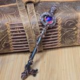 Decorative skeleton key with intricate wire wrapped design on a darkened steel surface