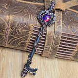 Decorative key with a gemstone on a textured leather surface