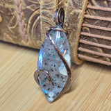 Decorative pendant with speckled design on a textured surface
