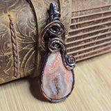 Decorative pendant with stone and wirework on a textured surface
