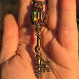 Antique skeleton key pendant with copper wire wrap and rainbow Aurora Opal.
