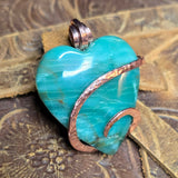 Green Jasper heart-shaped pendant with copper accents on a textured surface