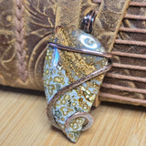 Jewelry pendant with textured design on a woven surface