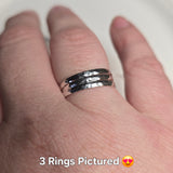 3 simple, sleek sterling silver band rings with a hammered finish, displayed on a person's hand.