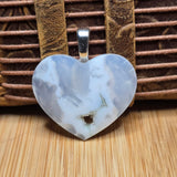 Heart-shaped pendant with a textured surface on a wooden background