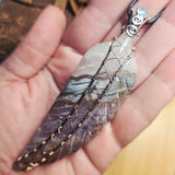 Tip of Amethyst Lace carved stone feather wrapped in sterling and rose gold fill in a hand
