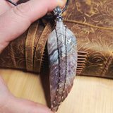 Amethyst Lace carved stone feather wrapped in sterling and rose gold fill in a hand