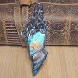 Labradorite lightning bolt with decorative elements on a textured wooden background