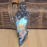 Decorative silver pendant on a wooden surface