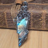 Labradorite lightning bolt pendant sterling silver on a wooden surface