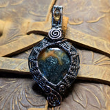 Decorative pendant with intricate design on a textured surface