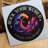 Colorful circular design with text on a white card, placed on a wooden surface.