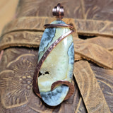 Oregon Bumblebee Plume pendant with copper accents on a textured leather surface