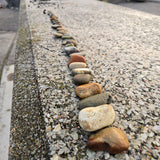 Row of stones arranged on a concrete surface