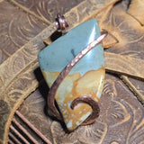 Pendant with turquoise and brown stone on a textured surface