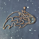 A copper wire sculpture of a meteor against a black spotted background
