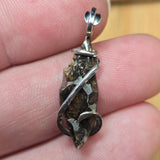 Silver pendant with natural stone held between fingers