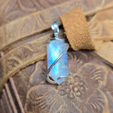 Pendant with a reflective stone on a leather surface