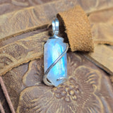Moonstone pendant against a textured brown leather background