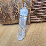 Crystal pendant on a wooden surface with a textured background