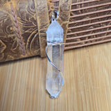 Crystal pendant on a wooden surface with a textured brown background
