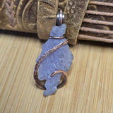 Decorative pendant with copper wire wrapping on a wooden surface