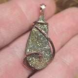 Sparkly pendant held between fingers with a blurred background