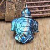 Turtle-shaped pendant with a metallic sheen on a wooden surface