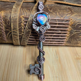 Antique key pendant against a neutral background