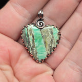 Variscite stone pendant held in a hand