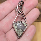 Pendant with a natural stone design held in a hand