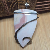 Marble-patterned pendant with silver accents on a wooden surface