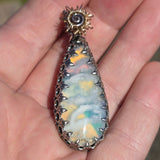 Multicolored bagate stone in sterling mount being held in hand